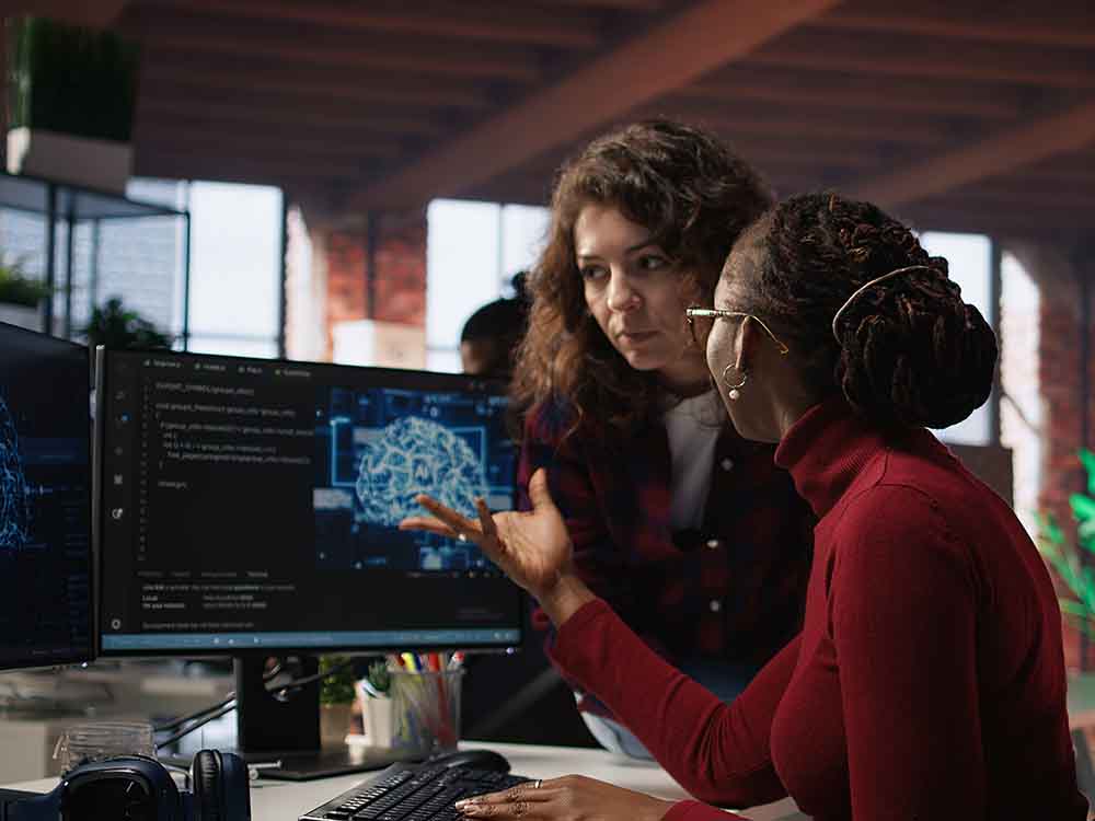two women working using ai