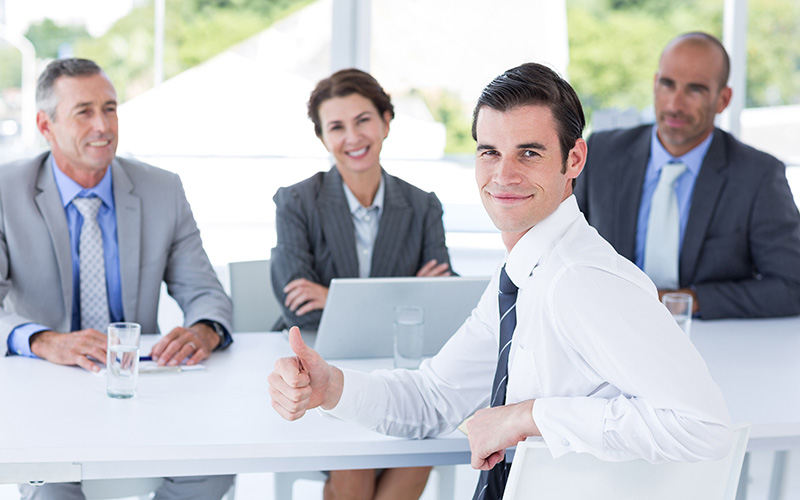 Young man giving thumbs up after a panel job interview